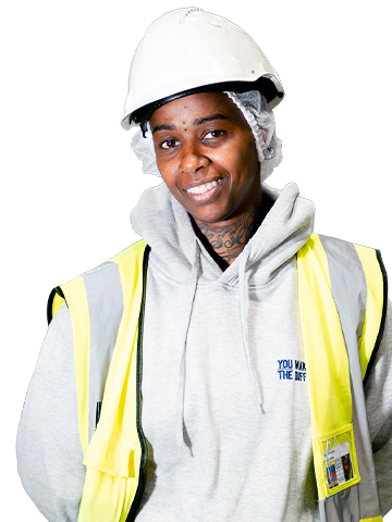A happy Pilgrim's Europe employer wearing a high visible jacket standing with their arms behind their back